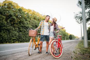 Young man and woman with retro bikes. Couple on vintage bicycles. Old cycles, romantic date