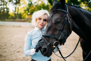 Portrait of woman and horse, horseback riding. Equestrian sport, young woman and beautiful stallion, farm animal