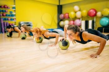 Women group with balls doing push up exercise, fitness workout. Female sport teamwork in gym. Fit class, aerobic