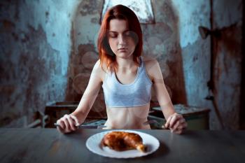 Unhappy skinny woman against plate with food, absence of appetite. Fat or calories burning concept. Weight loss, anorexia