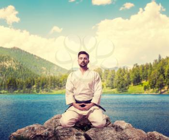 Traditional martial arts, master meditate, lake on background, black belt, outdoor training