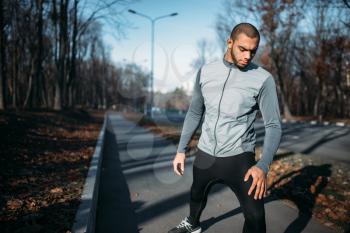 Male jogger on fitness workout outdoors. Runner in sportswear on training in park. Jogging or running