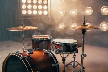 Drum kit, percussion instrument on the stage with lights, nobody. Drummer professional equipment, beat set
