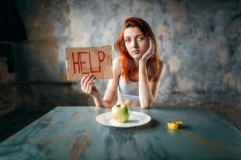 Young woman holds help sign in hand against plate with apple. Weight loss diet concept, fat burning