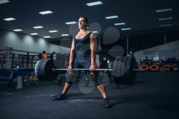 Male powerlifter preparing deadlift a barbell in gym. Weightlifting workout, lifting training, athlete works with weight in sport club