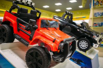 Electric car on showcase in toy store, nobody. Toyshop interior, motor automobile for children