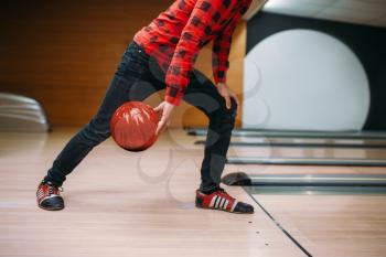 Male bowler makes throw, closeup view on hand with ball. Bowling alley player, throwing in action, classical tenpin game in club