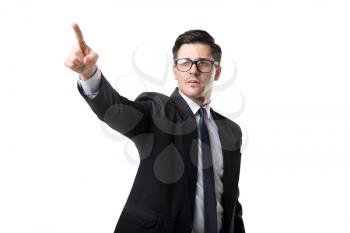 Young bisnessman in glasses, tie and black suit point a finger up, isolated on white background