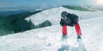 Skier in helmet and glasses riding a snow hill. Winter active sport, extreme lifestyle. Skiing in mountains