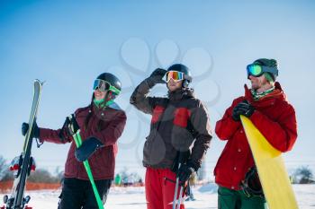 Skiers and snowboarder poses together, winter active sport. Skiing from mountains, snowboarding, extreme lifestyle
