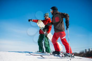 Downhill skiing, male and female skiers on the top of slope. Winter season active sport, extreme lifestyle
