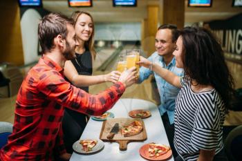 Friends drinks juice and eats pizza in bowling club, active leisure, healthy lifestyle, bowling game
