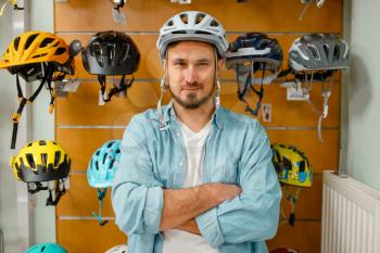Man trying on cycling helmet, shopping in sports shop. Summer season extreme lifestyle, active leisure store, customers buying bicycle protect equipment