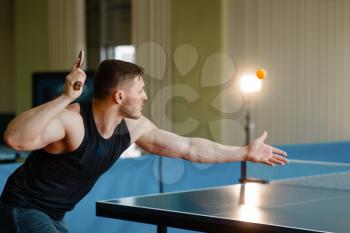 Man with ping pong racket, hit the ball in action, workout indoors. Male person in sportswear, training in table tennis club