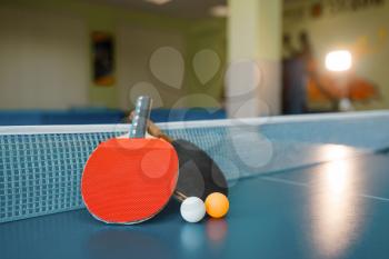 Two ping pong paddles on the table with net, nobody, closeup view. Table-tennis club, tennis concept