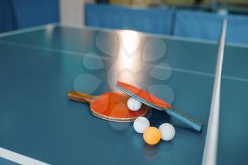 Two ping pong rackets and balls on game table with net, nobody, closeup view. Table-tennis club, tennis concept, ping-pong