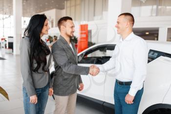 Manager gives the couple a new car in showroom. Male and female customers looks vehicle in dealership, automobile sale, auto purchase
