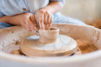 Female potter making a pot on pottery wheel. Woman molding a bowl. Handmade ceramic art, tableware from clay