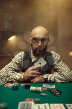 Bearded poker player show ace card, casino. Games of chance addiction. Man leisures in gambling house, gaming table