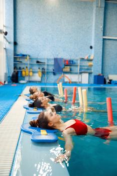 Female swimmers group, aqua aerobics training at the poolside. Women in the water, swimming fitness workout in pool