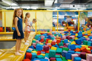 Cute children jumping on kids trampoline, playground in entertainment center. Play area indoors, playroom