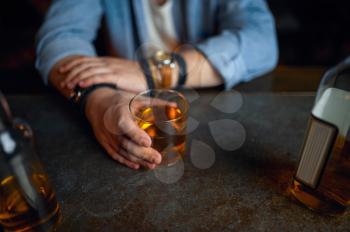 Drunk man pours alcohol at the counter in bar. One male person resting in pub, human emotions and leisure activities, depression