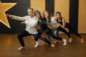 Contemporary dance performers in studio, snapshot in action. Female and male dancers training in class, modern grace dancing, stretching exercise, aerobic