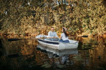Love couple boating on lake at summer day, water reflection. Romantic data, boat ride, man and woman walking along the river