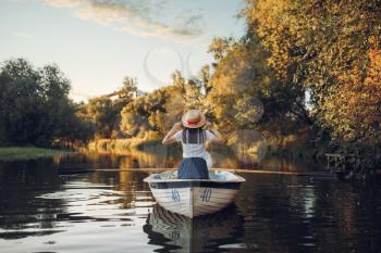 Love couple in boat on quiet lake at summer day, daydream. Romantic date, boating trip, man and woman walking along the river