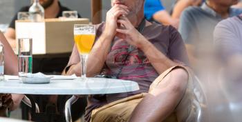 People drinks beer in street cafe in old European tourist town. Summer tourism and travels, famous europe landmark, popular places for travelling