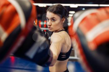 Woman in gloves boxing in the ring with trainer, box workout. Female boxers in gym, kickboxing sparring partners in sport club, punches practice