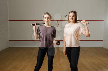 Two female players shows squash rackets. Girls on training, active sport hobby, fitness workout for healthy lifestyle