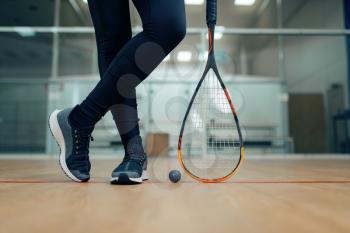 Female player legs, squash racket and ball. Girl on game training, active sport hobby on court, fitness workout for healthy lifestyle