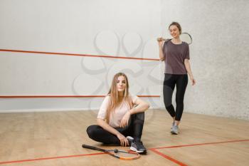 Two female squash players poses on court. Youth on training, active sport hobby, fitness workout for healthy lifestyle