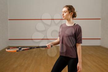 Female player with squash racket and ball on court. Girl on game training, active sport hobby, fit workout for healthy lifestyle