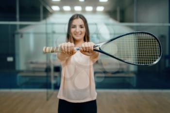 Female player shows squash racket on court. Girl on game training, active sport hobby, fit workout for healthy lifestyle