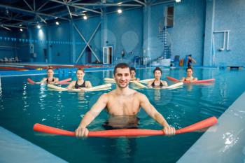 Male trainer and female group, aqua aerobics training in the pool. Man and women in the water, sport swimming fitness workout