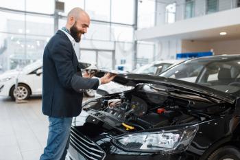 Man looking on transport engine in car dealership. Customer in new vehicle showroom, male person buying automobile, auto dealer business