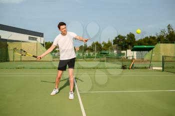 Male tennis player with racket hits the ball on outdoor court. Active healthy lifestyle, sport game competition, fitness training with racquet