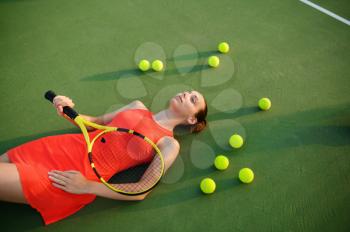 Tired female tennis player with racket lies on outdoor court. Active healthy lifestyle, sport game competition, hard fitness training with racquet