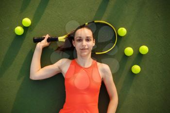 Tired female tennis player with racket lies on outdoor court. Active healthy lifestyle, sport game competition, hard fitness training