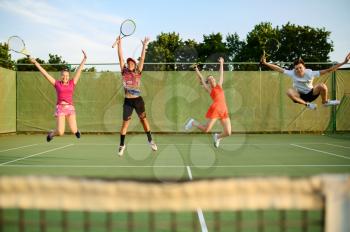Mixed doubles tennis, happy players jump near the net, outdoor court. Active healthy lifestyle, sport with racket and ball, fitness workout with racquets