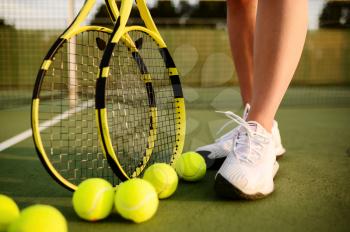 Female tennis player with racket and many balls on outdoor court. Active healthy lifestyle, sport game competition, fitness training with racquet