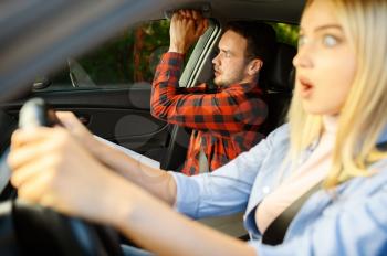 Scared woman and instructor in car, driving school. Man teaching lady to drive vehicle. Driver's license education, accident situation