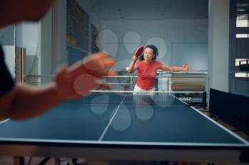 Sportive Man and woman, table tennis training, ping pong players. Couple playing table-tennis indoors, sport game with racket and ball, active healthy lifestyle