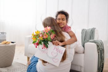 Little daughter wishes her beloved mother a happy birthday in living room.Mom and female child embracing, good relationship, parental care and love