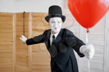 Mime artist with air balloon, comedy parody. Pantomime theater, comedian, positive emotion, humour performance, funny face mimic and grimace