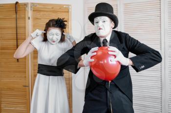 Two mime artists, scene with air balloon, comedy parody. Pantomime theater, comedian, positive emotion, humour performance, funny face mimic and grimace