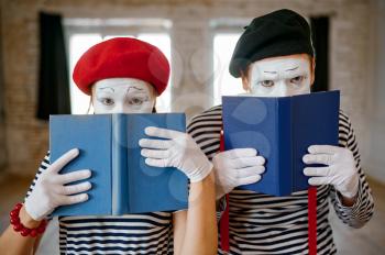 Mime artists, scene with books, parody comedy. Pantomime theater, comedian, positive emotion, humour performance, funny face mimic and grimace