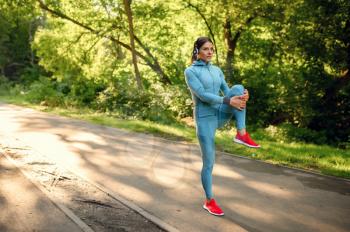 Morning fitness training in park, woman in headphones running on walkway. Female runner goes in for sports at sunny day, healthy lifestyle, jogger on outdoors workout